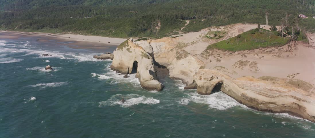 The rough waves crash against the beach below