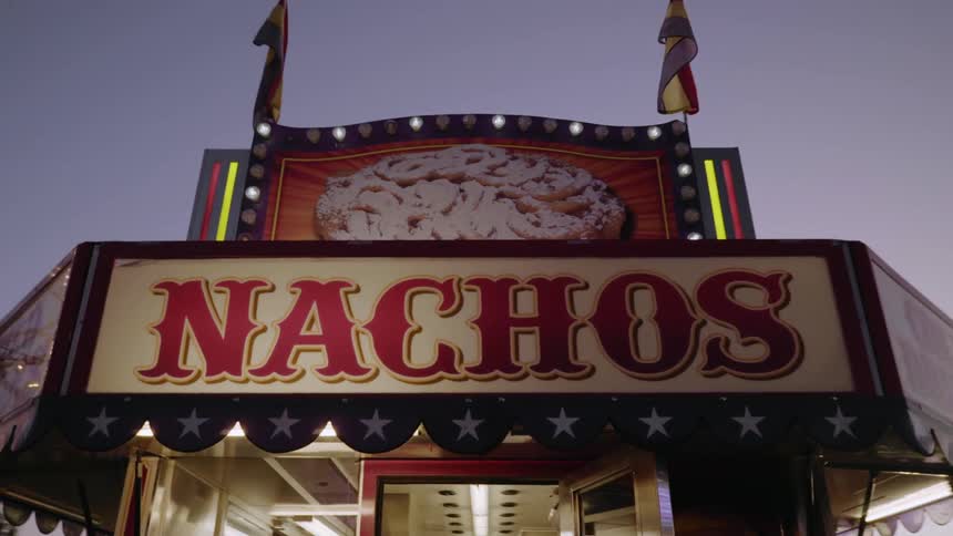 Flashing lights help advertise a food stand for nachos at a carnival