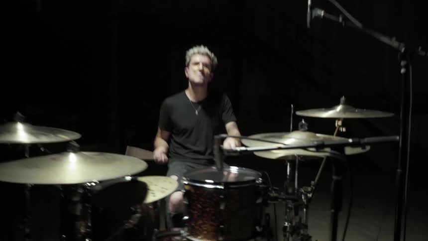 Man play drum in the spotlight in a dark room