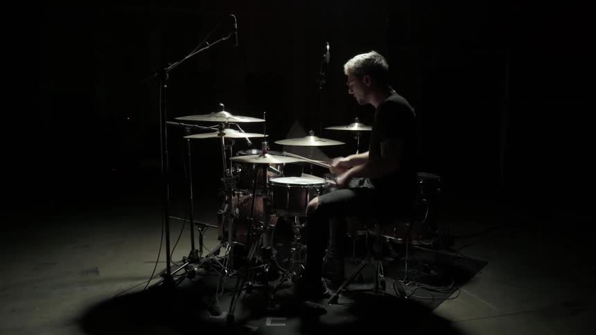 A young man plays the drums