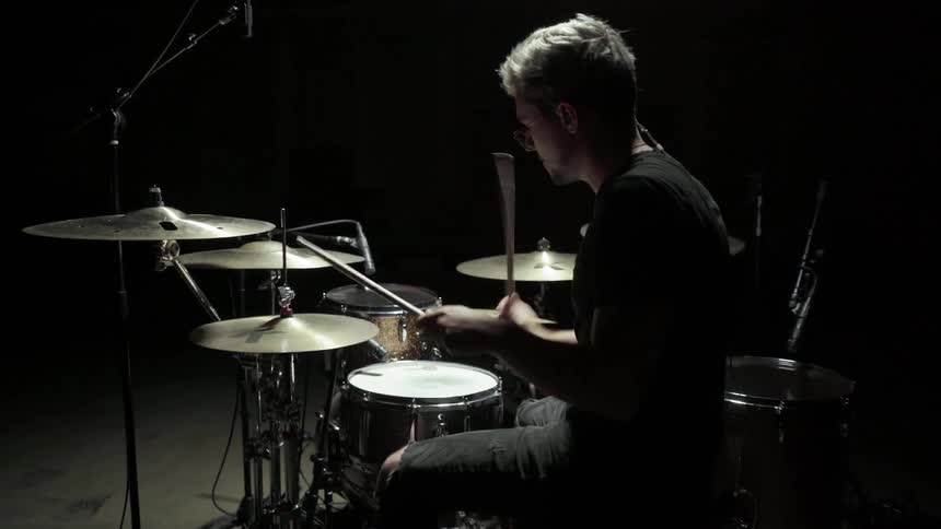 Drummer plays on his drum kit