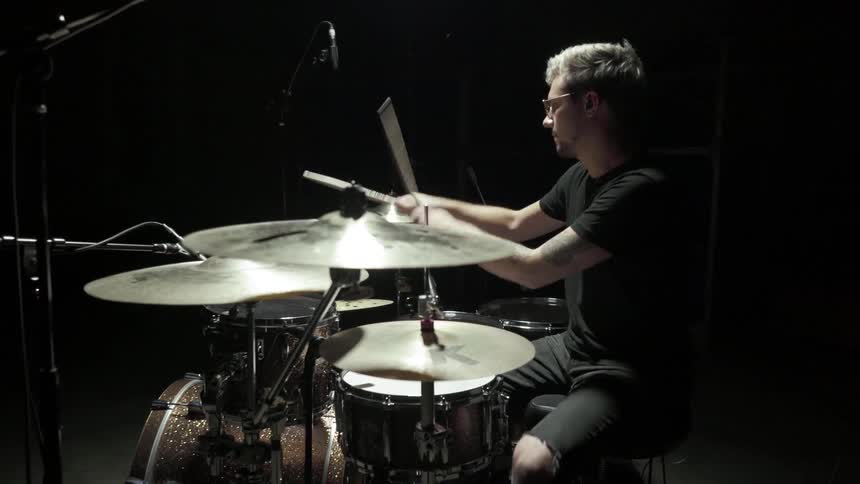 A man bops his head while playing the drums