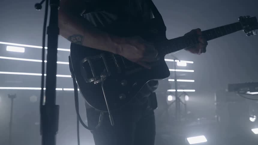A man plays an electric guitar on a stage