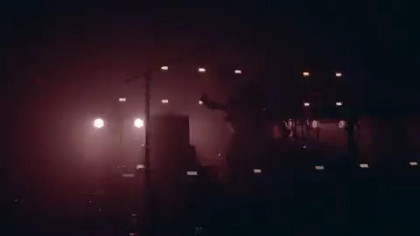 A person is playing a guitar on a stage with strobe lights flashing all around them