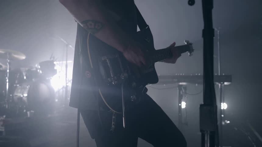 A man playing guitar on a stage in a dark room