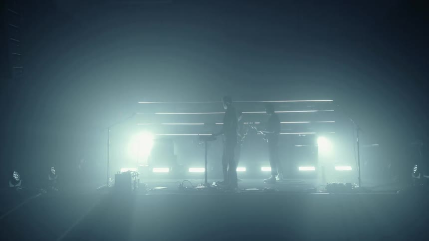 Two men perform music on a stage