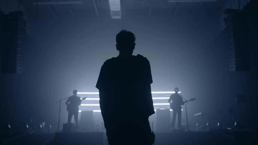 A man is dancing as he watches a band on stage
