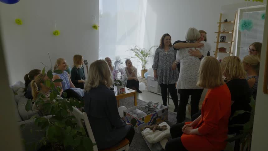 A white woman hugs three other white women at a party