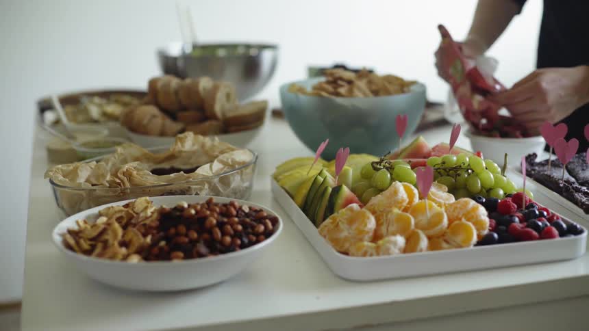 Woman puts food in the bowl on the table indoors