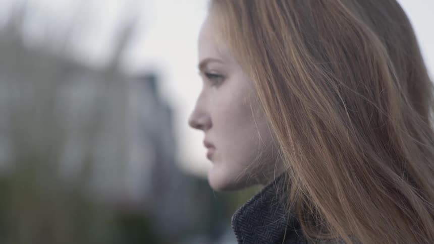 A young white woman stares into the distance