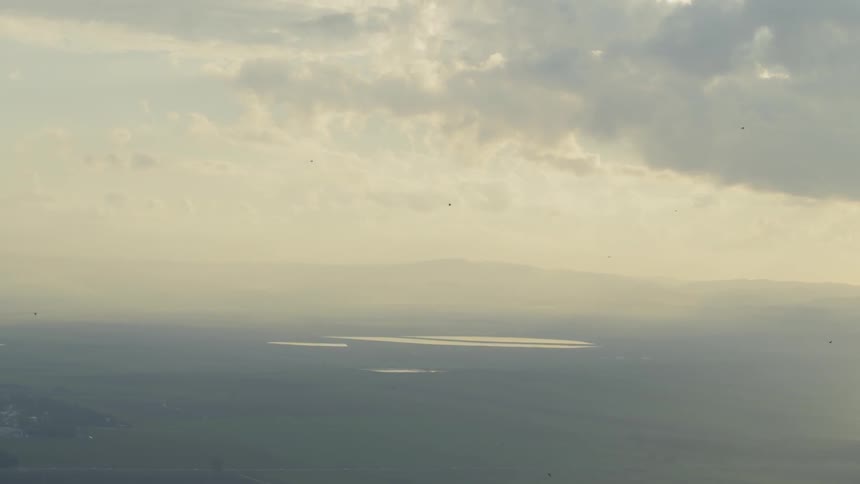 The boats are traveling through the water in the distance