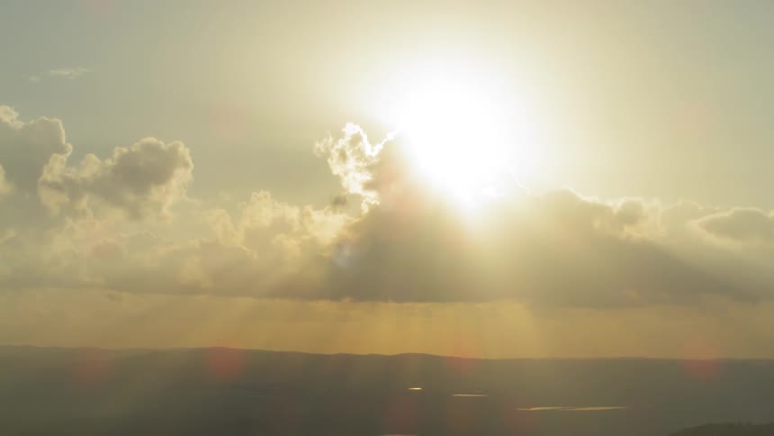 The sun shines behind a bank of clouds