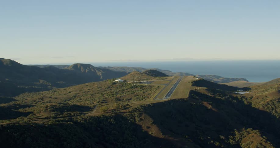 Mountain runway landing strip surrounded by ocean