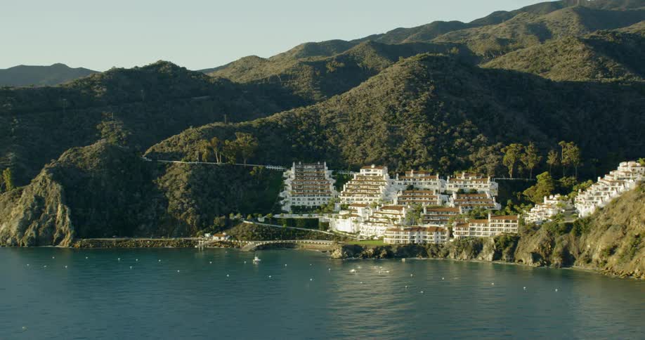 A small town rests on a mountainous shoreline