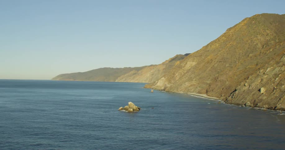 A mountain range towers over the ocean