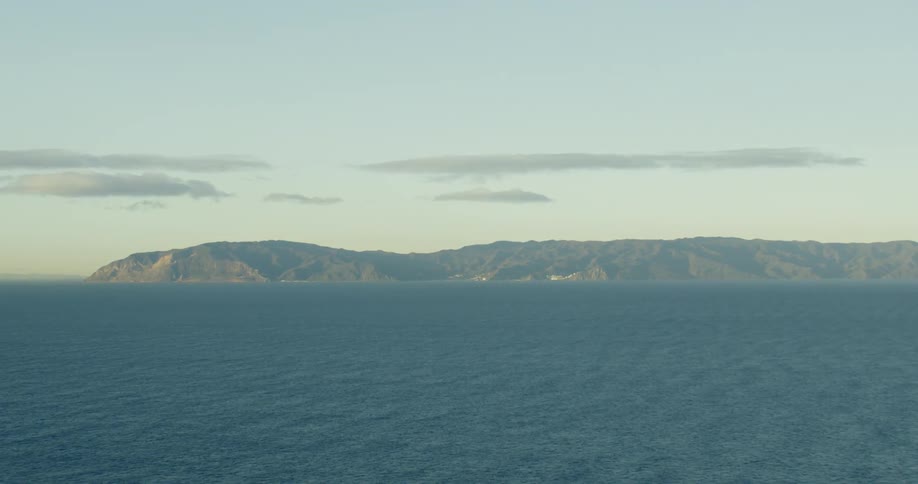 The ocean viewed from air with a landmass in the distance