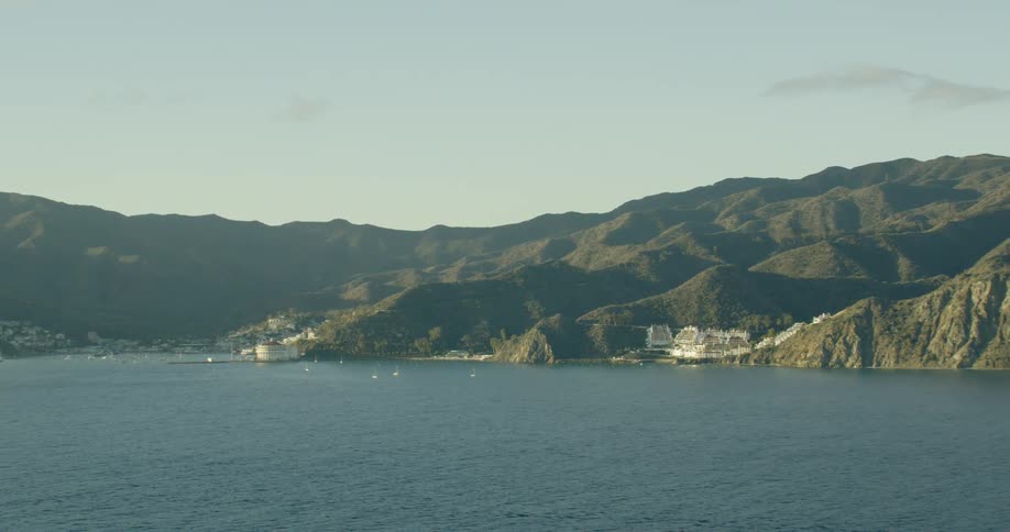 White buildings and beaches on the green hilly coast on a sunny day