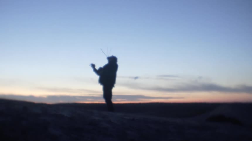 Silhouette of a man with sticks in his mouth