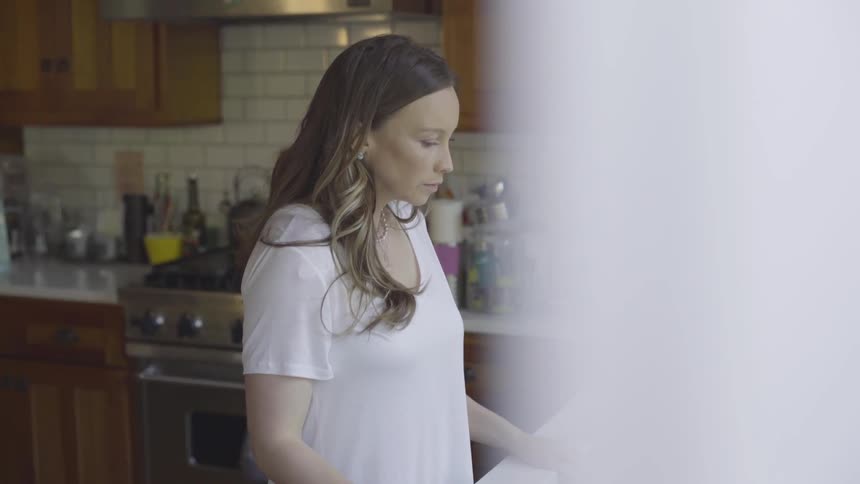 A woman standing at a kitchen sink