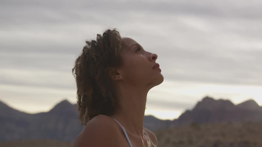 A woman in the desert looking up at the sky