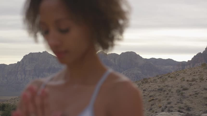 A woman meditates in a desert