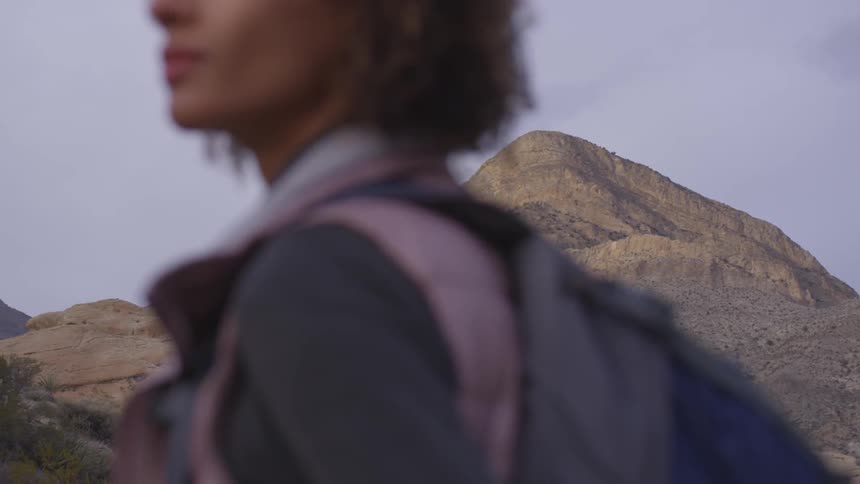 A woman with a backpack hikes in mountains