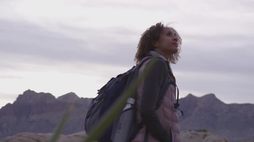 Woman stands outdoors looking at scenery