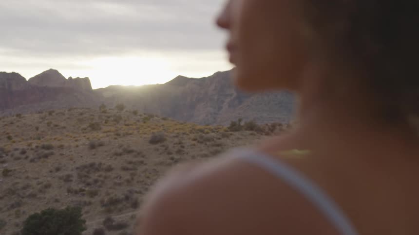 A woman standing in a desert on a cloudy day