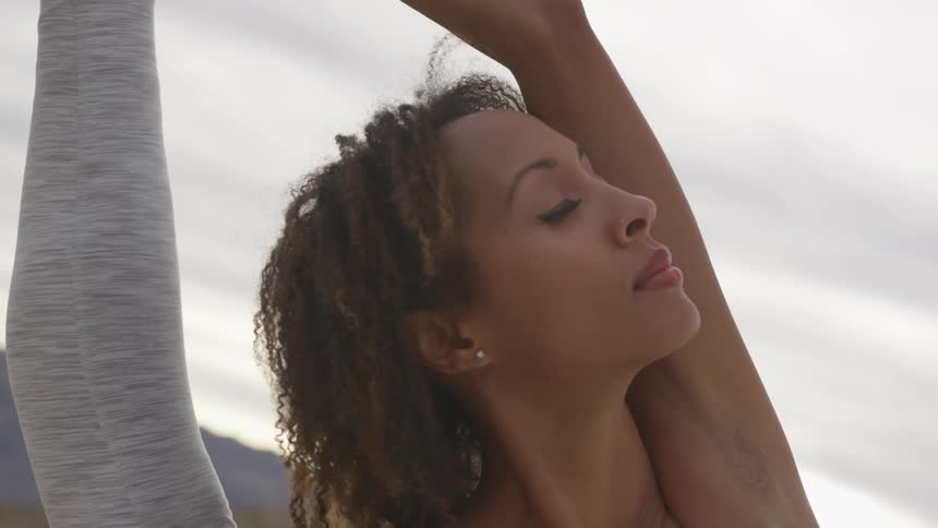A woman stretches with her leg pulled up high