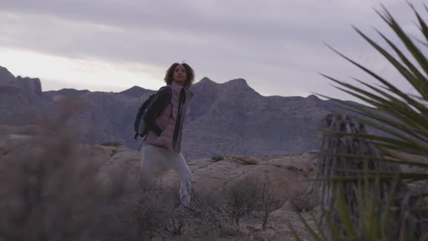 Woman with backpack hiking on a desert