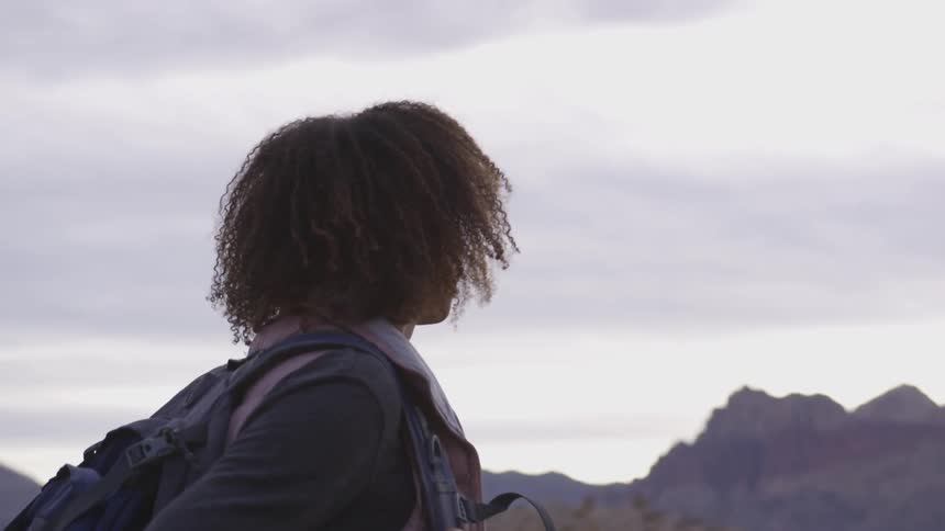 A hiker pauses to look at a mountain range