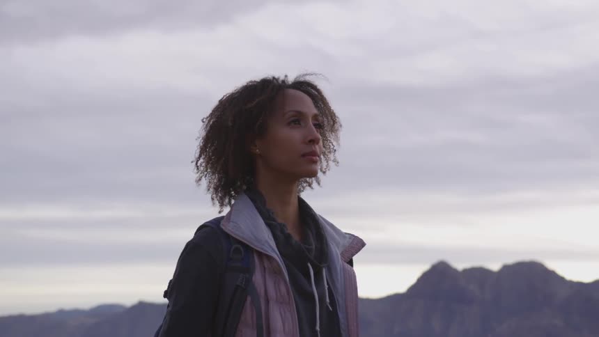Woman standing on a desert looking at the horizon