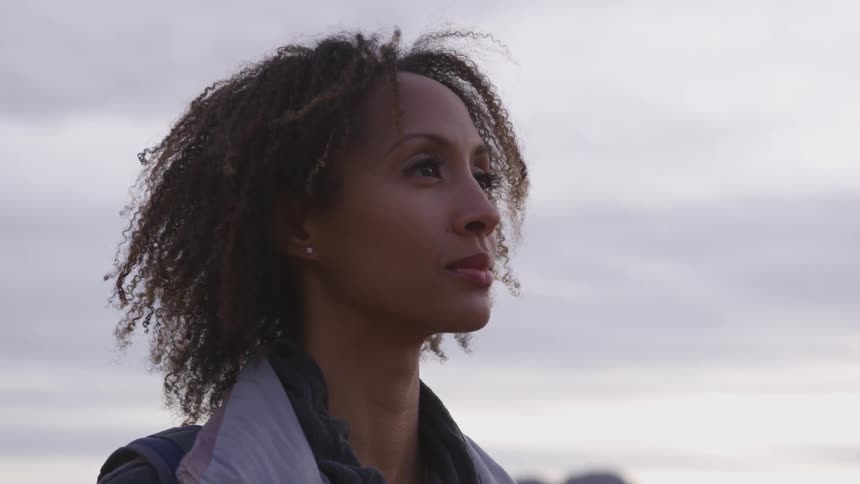Woman with curly hair looking at the horizon