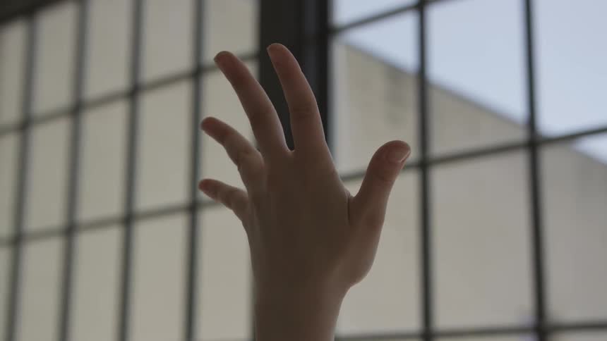 A white woman holds her spread hand up in the air
