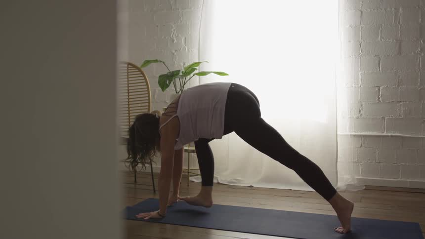 A woman stretches into different yoga positions