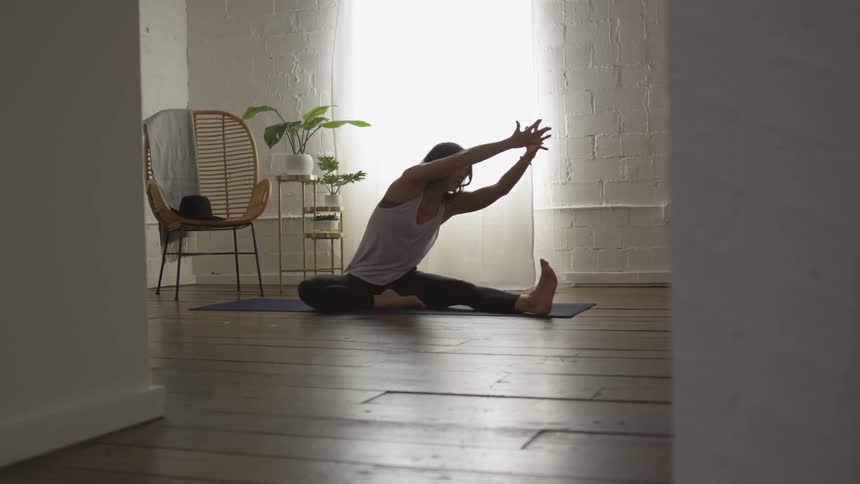 Woman practicing yoga on a mat indoors