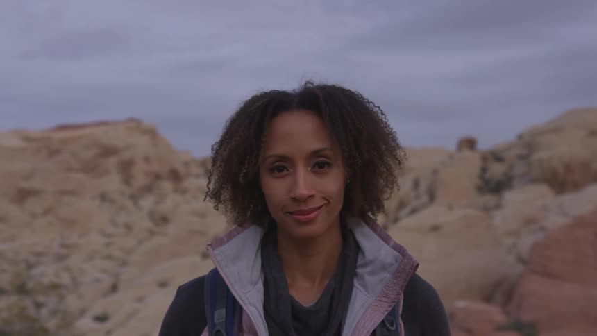 A woman standing in a national park smiling