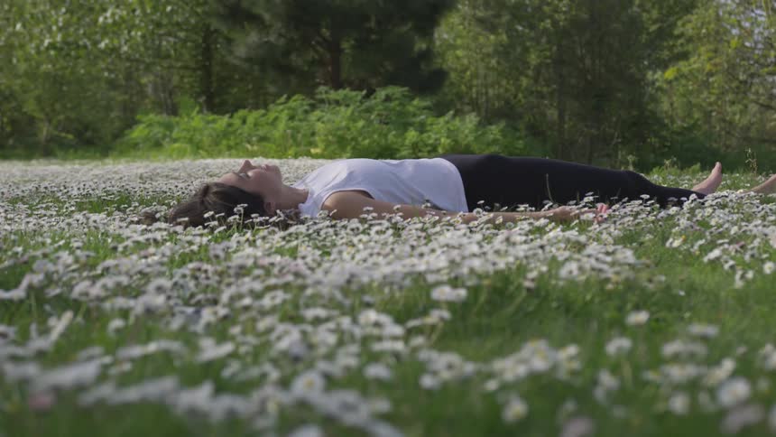 A woman laying in a patch of flowers