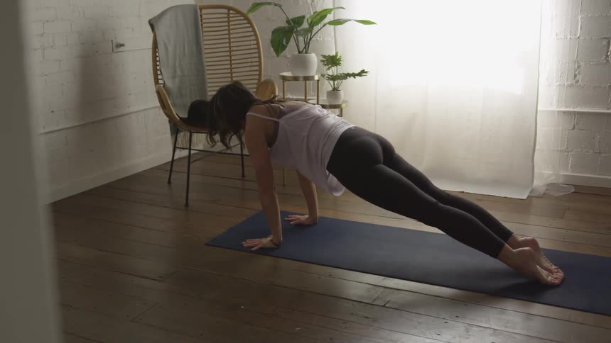 Woman practicing yoga on a mat indoors