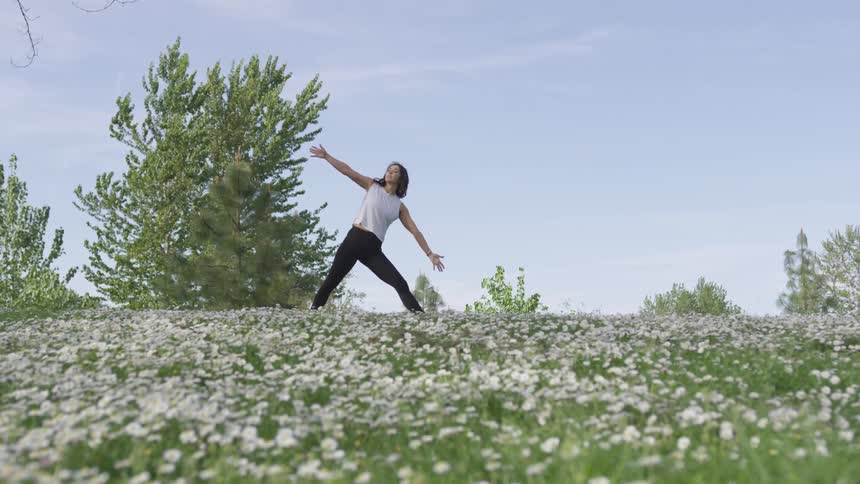 A woman practices yoga in a field full of flowers