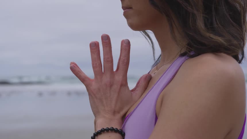 Woman practicing yoga on the beach