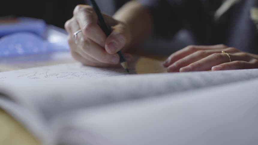 A person draws in a notebook