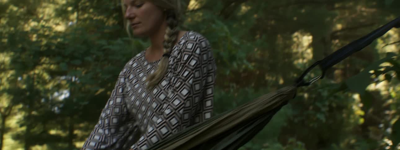 Woman opening a hammock in the forest