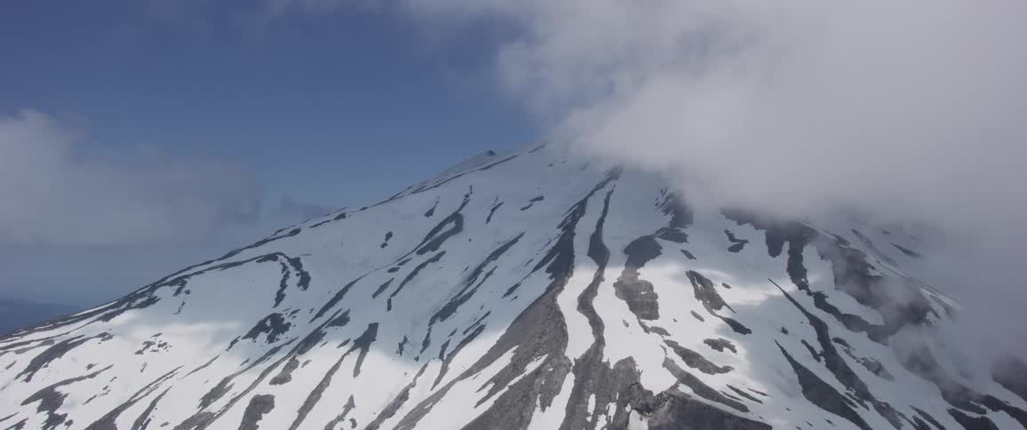 Mountain top covered with snow and clouds