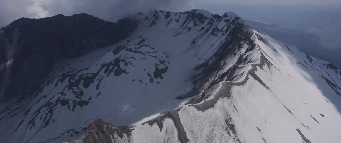 An aerial view of a mountain ridge on a cloudy day