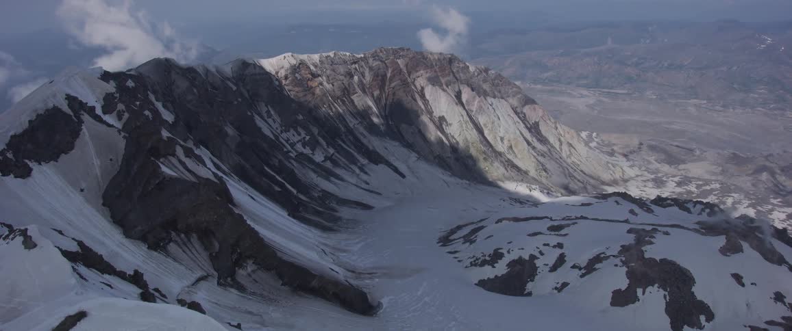 An aerial view of the summit of a mountain that's covered in snow