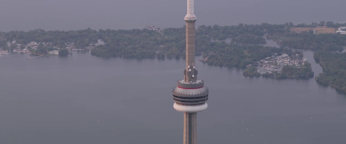 A tall building structure sits in a city beside a river