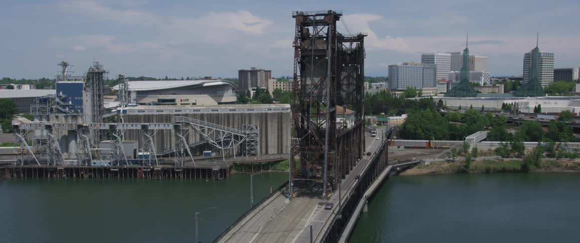 A vehicle bridge over a body of water that connects to a large city
