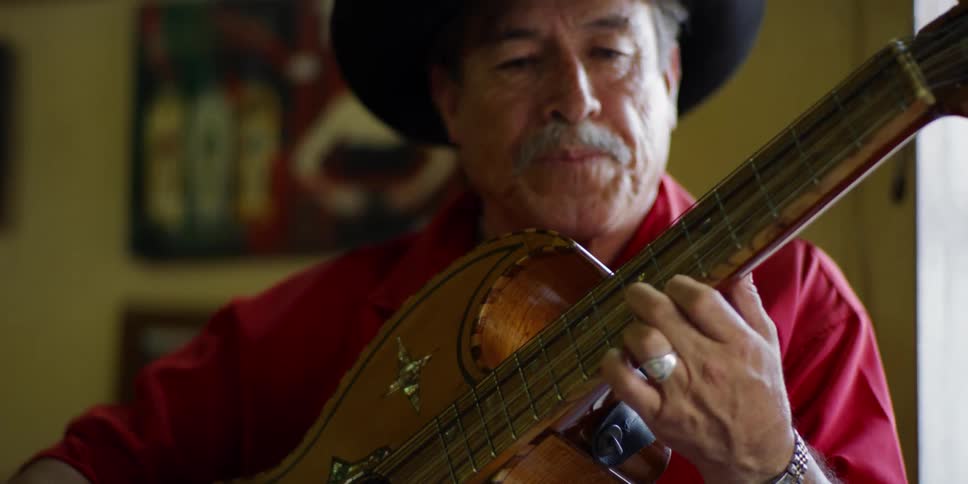 Man with cowboy hat singing and playing the guitar