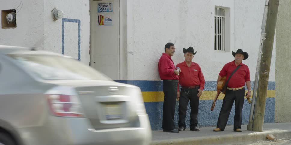 Musicians stand outside building talking